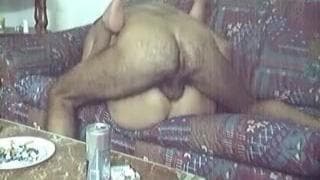 Ele abre as pernas dela e fode-a no sofá