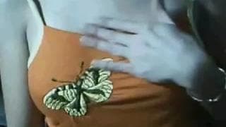 Ela tira a blusa para revelar seus peitos