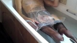 Ele coloca meia-calça preta na banheira