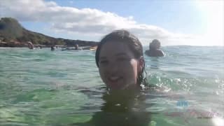 Esta jovem é pegada na praia ao sol Esta jovem é pegada na praia ao sol