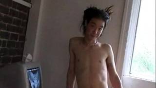 Homem magro asiático esguicha esperma na frente de seu computador