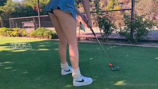 No minigolfe há uma garota que quer pontaria no buraco