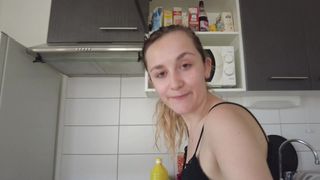 Louise está na cozinha fazendo um prato novo e nua